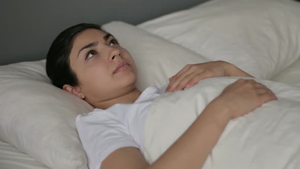 Pensive Indian Woman Laying Awake in Bed 