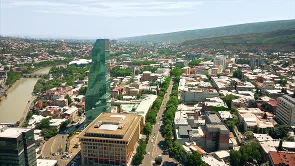 Aerial drone view of the city. Multiple buildings, business center, a lot of greenery, Kura river, r