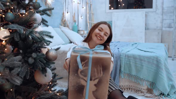 Close Up of Happy Beautiful Woman in White Shirt Offering a Gift Box