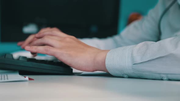 A Man is Working at a Computer in the Office