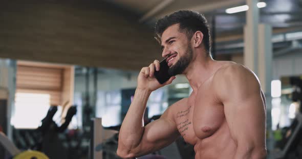 Sport Man with a Naked Body Speaking on Phone in a