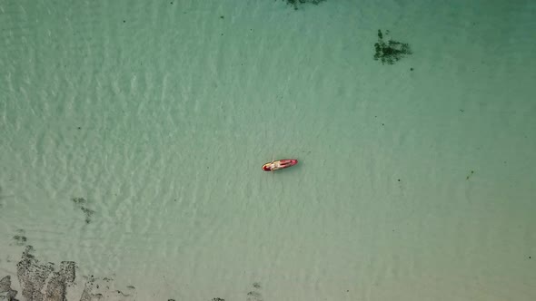 Woman Relaxing in the Sea on a Surfboard