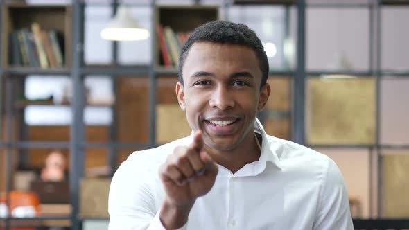 Black Man Pointing to Camera in Office