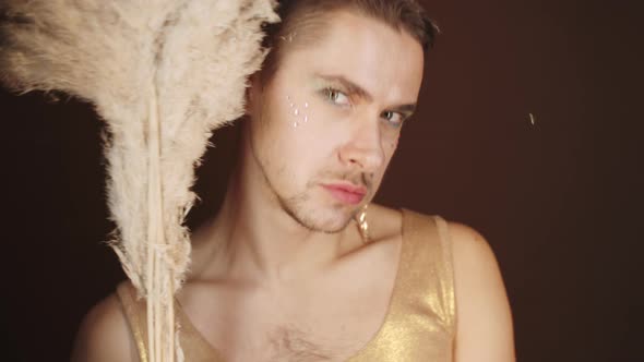 Expressive Gay Man in Fancy Dress Posing with Pampas Grass