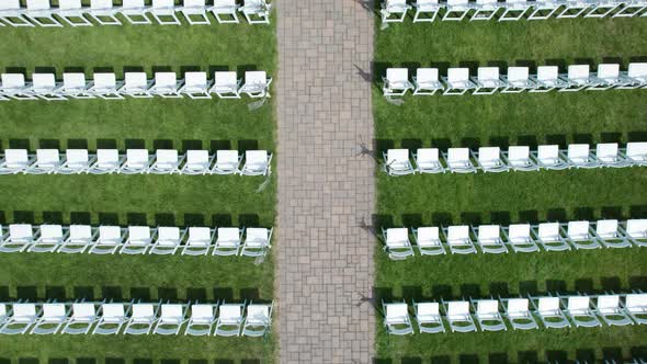 Drone aerial of a wedding ceremony setup with chairs in a garden
