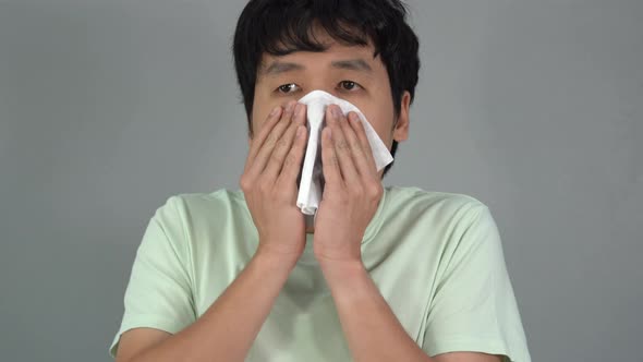 sick young man is sneezing