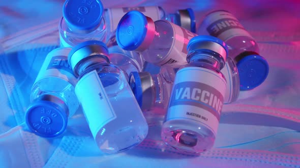 Group of vaccine bottles on face masks.