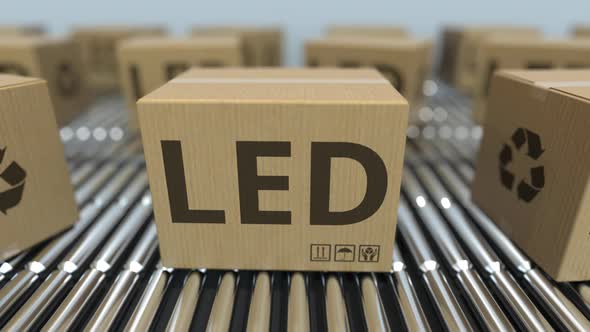 Cartons with LED Lighting Equipment on Roller Conveyors