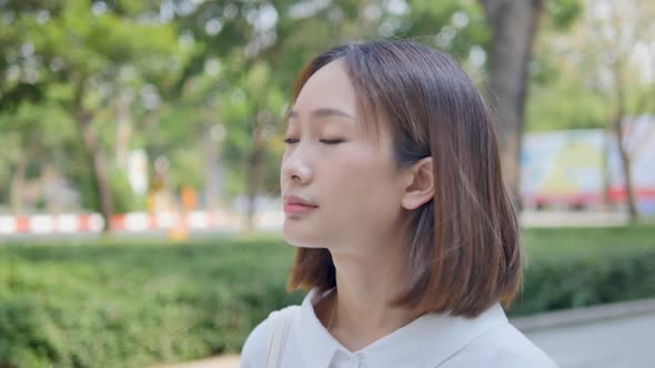 Asian girl is walking in the park watching the sunset.