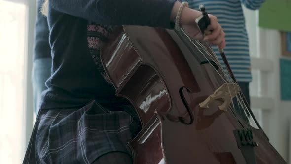 Girl playing cello during lesson