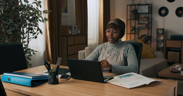 A Busy Woman Jots Down Information on Laptop After a Client Meeting