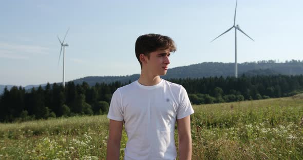 Outdoor of Men Activist with Save the Planet Ecology Poster. In Background Forest and Wind Turbine