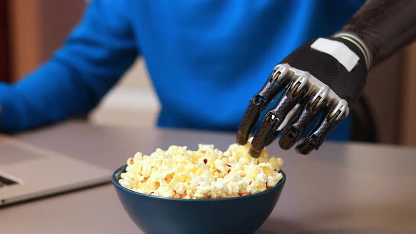 Young Man Watching a Movie in Laptop and Eating Pop Corn at Home
