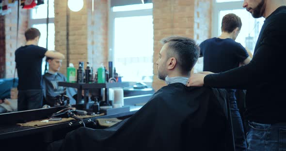 Hairdresser Removes a Paper Collar From the Neck of the Client and Removes the Cape