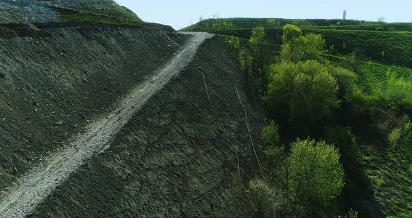 View from above of the side of a hill made of garbage dump.