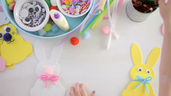 Step by step. Mother and daughter decorating Easter Bunnies.