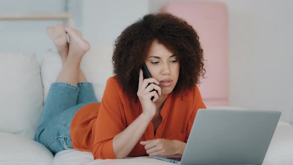 Relaxed Emotional African American Girl with Curly Hair Resting at Home Bedroom with Laptop Chatting