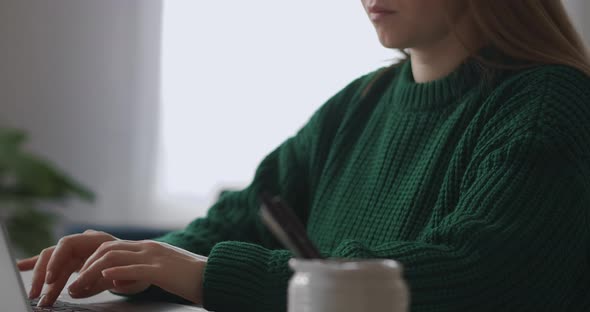 Freelancer Woman Is Working with Laptop in Home Closeup View of Hands on Keyboard and Face Typing