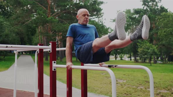 Active and Powerful Old Man Workout on Sports Playground with Gym Equipment