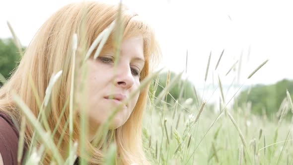 Caucasian blonde woman playing in the field with grass 1080p slow motion HD footage - Beautiful blon