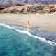 Aerial Drone Footage of a Girl Walking Along a Lonely Beach - VideoHive Item for Sale