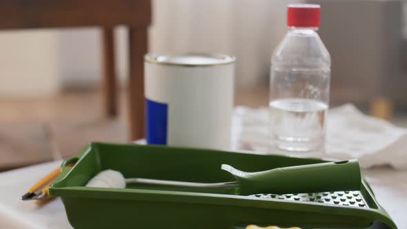 Paint Roller and Bottle of Solvent on Table