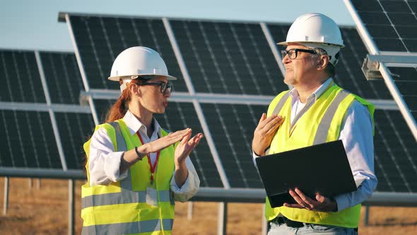 Two Solar Energy Specialists Talking at a Solar Panel Facility