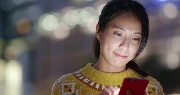 Woman Read on Mobile Phone in City at Night