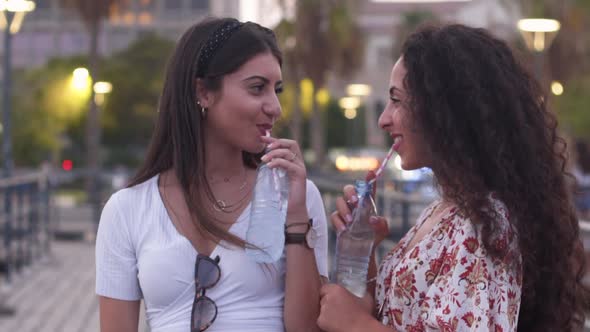 Young Multiethnic Women Drinking Water and Having Fun in City