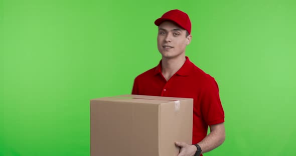 Delivery Worker in Red Uniform Offering Parcel To Camera