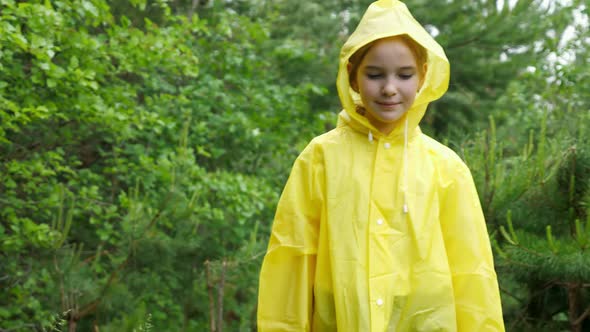 Happy Girl in Yellow Raincoat Walks Enjoying Summer Nature