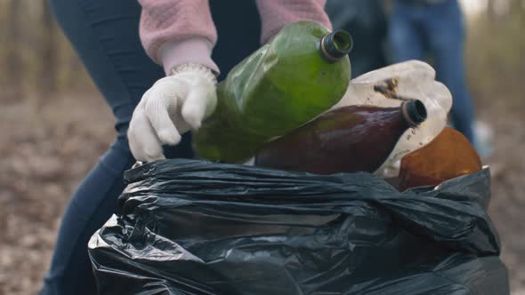 Woman Putting Household Waste Into Bin Bag