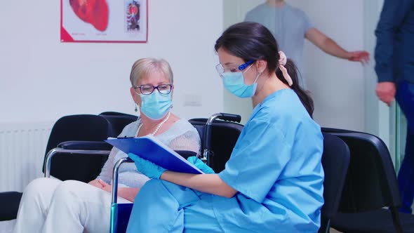 Nurse Explaining Diagnosis to Elderly Disabled Woman