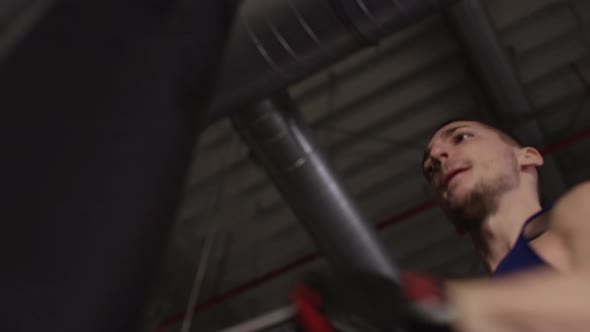 Low angle of a man punching a punching bag