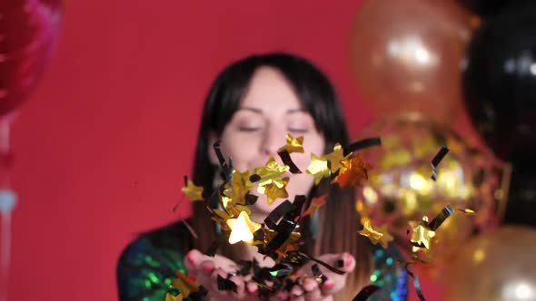 Happy Woman Blowing Gleaming Confetti To Camera