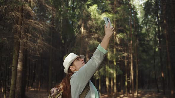 Traveler Woman Trying To Catch a Cell Signal on the Phone in the Forest, No Signal on the Phone