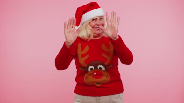 Grandmother Woman in Christmas Sweater with Deers Waves Hand Palm in Hello Gesture Welcomes Someone