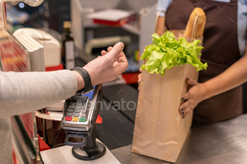 rtwatch over screen of payment machine standing by cashier counter in supermarket