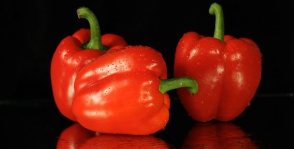 Fresh Red Peppers Rotating On Black Background