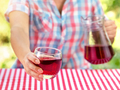 Woman holds out glass of wine or grape juice over table - PhotoDune Item for Sale