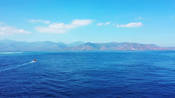 Tropical fly over clean view of a white sandy paradise beach and blue water background in 4K