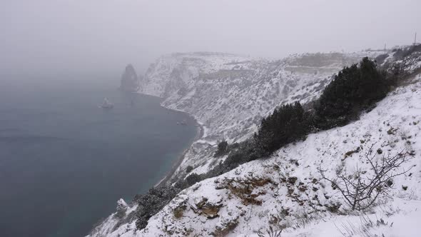 Snow Covered Rocky Cliffs Over Sea