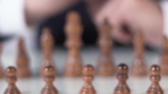 Close Up of Male Hand Moving Pawn in Chess Game, Business and Political Strategy