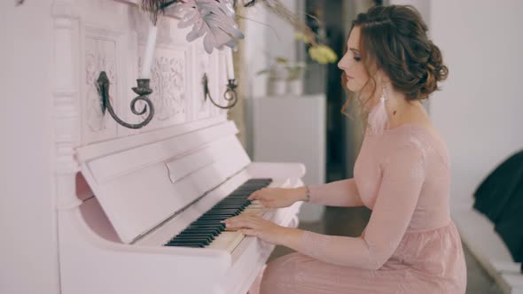 Young Beautiful Woman in Dress Playing on Piano