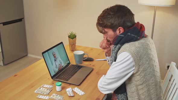 Sick Man in Selfisolation Communicates with a Doctor By Video Call Using a Laptop a Patient Consults