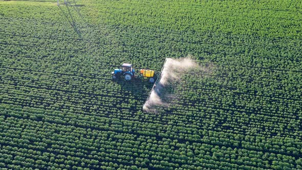 Tractor Is Spraying Fertilizer Over the Field While Riding Along It. Chemicals Used By Agricultural