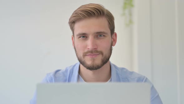 Portrait of Creative Man with Laptop Smiling at Camera