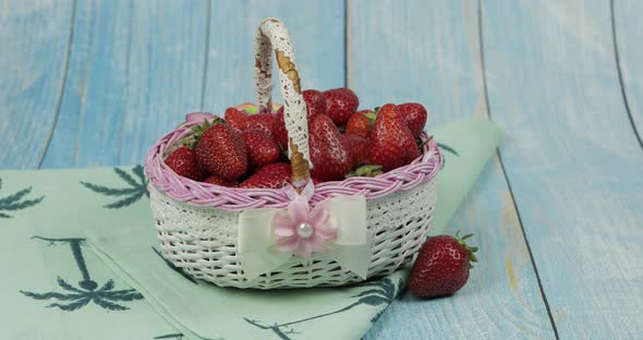 Strawberries in a Small Basket on the Blue Wooden Table