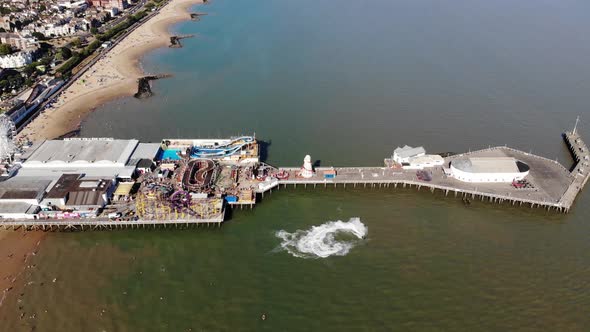 Aerial view panning down on a ski-jet making circles in the water near the Clacton-on-Sea pier