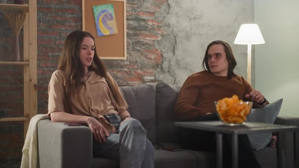 Young Woman and Long Haired Man at Sports Game in Flat